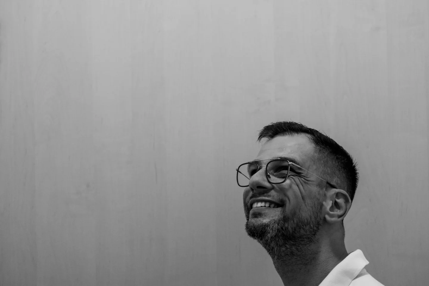 Zwart-witportret van Ruben Ras, glimlachend en omhoogkijkend